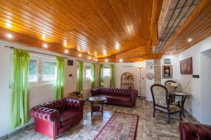 een woonkamer met lederen meubels en een houten plafond bij Non stop apartman in Kaposvár