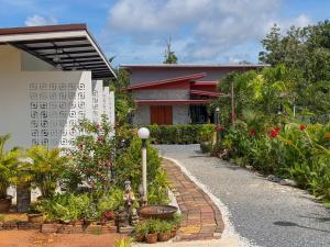 ランタ島にあるThawat Villa Boutique Resortの花の庭園と散歩道のある家