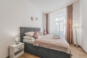 a bedroom with a large bed and a window at Stylový byt v srdci Hradce Králové in Hradec Králové