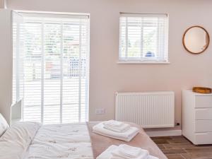 a white bedroom with a bed and a window at Elm - Uk50463 in Alvington