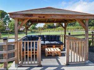a wooden gazebo with a couch on a deck at Elm - Uk50463 in Alvington +3 photos