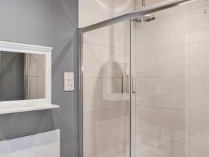a shower with a glass door next to a mirror at Elm - Uk50463 in Alvington