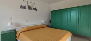 a bedroom with green cabinets and a bed at Tana di Zia Nature, Yourself, Love in Viggianello