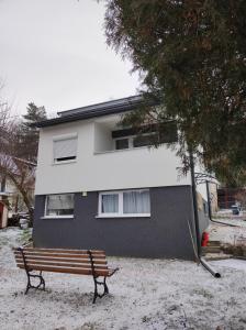 Un banco de madera situado frente a un edificio. en Döbrönte MagLak, en Döbrönte