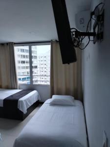 een hotelkamer met twee bedden en een raam bij Atardeceres del Laguito in Cartagena