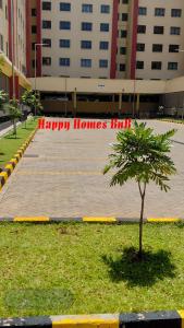 a tree in the grass in front of ahappy homeshi sign at Happy Homes BnB in Kisumu