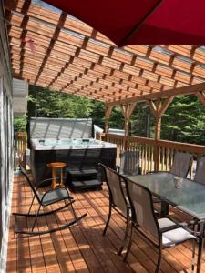 een patio met een grill en een tafel en stoelen bij Chalet Le Mona in Notre-Dame-Des-Bois