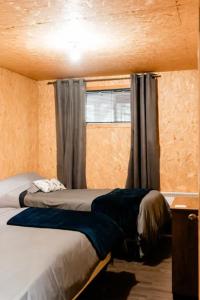 een kleine slaapkamer met een bed en een raam bij Chalet Le Mona in Notre-Dame-Des-Bois