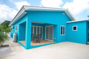 una casa azul con un patio frente a ella en The Blue Nest, en Dorp Sint Michiel