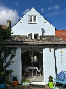 a white house with a window and a table at Riverside cottage in Deeping Saint James