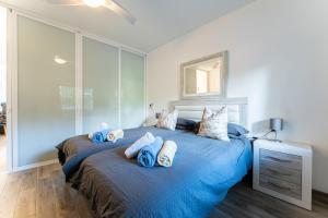 a bedroom with two beds with blue blankets at Calahonda Beach Apartments in Sitio de Calahonda