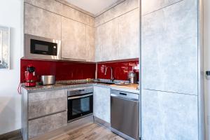 a kitchen with red walls and stainless steel appliances at Calahonda Beach Apartments in Sitio de Calahonda +16 photos