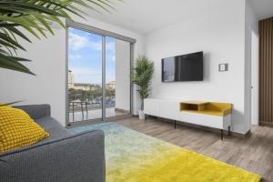 een woonkamer met een tv en een bank bij Relaxing 2BR2BA Condo w/ Gym, Pool in Palm Beach! in Palm-Eagle Beach