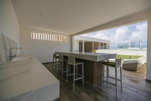 een keuken met een bar met een spoelbak en een badkuip bij Relaxing 2BR2BA Condo w/ Gym, Pool in Palm Beach! in Palm-Eagle Beach