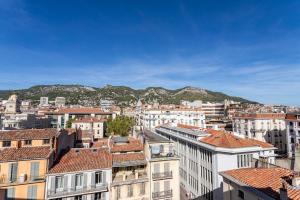 a city with buildings and mountains in the background at Splendide appartement climatisé vue mer in Toulon