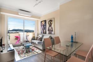 a living room with a glass table and a couch at Splendide appartement climatisé vue mer in Toulon