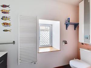 ein Badezimmer mit Toilette und Fenster in der Unterkunft La petite Mainerie in Jobourg + 4 Fotos