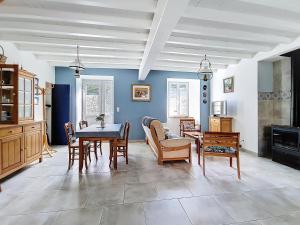 ein Wohnzimmer mit Tisch und Stühlen in der Unterkunft La petite Mainerie in Jobourg