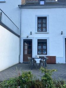 una casa blanca con una mesa y sillas frente a ella en Chez Germaine, en Bouillon