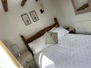 a bedroom with a bed and a mirror on the wall at Riverside cottage in Deeping Saint James