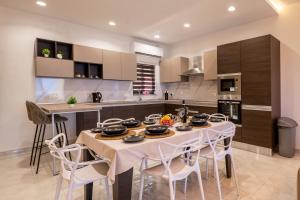 a kitchen with a table and chairs in a room at Modern SeaView Luxury Apartment in St. Paul's Bay