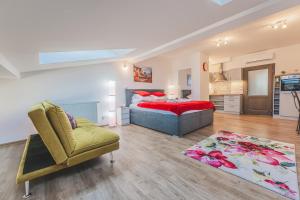 a bedroom with a bed and a chair and a rug at Podkrovní studio na Velkém náměstí s Wi-Fi zdarma in Hradec Králové