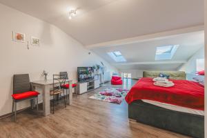 a bedroom with a bed and a desk and a table at Podkrovní studio na Velkém náměstí s Wi-Fi zdarma in Hradec Králové