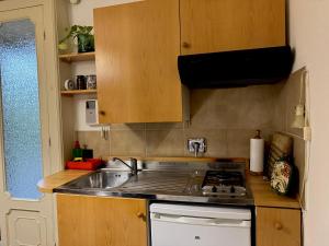 uma cozinha com pia e fogão forno superior em Casa al mare con parcheggio em Génova