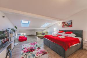 a bedroom with a large bed with a red blanket at Podkrovní studio na Velkém náměstí s Wi-Fi zdarma in Hradec Králové