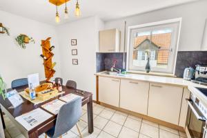 a kitchen with white cabinets and a wooden table at Apartment Bavaria - Zentral mit Stellplatz, Küche & Netflix in Pfaffenhofen an der Ilm