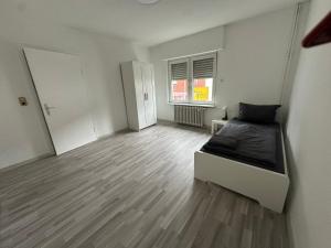 a bedroom with a bed and a wooden floor at HAI2 - Modern Unterkunft mit Einzelzimmer in Hainburg