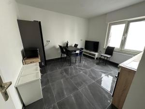a living room with a table and chairs and a television at HAI2 - Modern Unterkunft mit Einzelzimmer in Hainburg