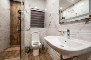 a white bathroom with a sink and a toilet at Modern SeaView Luxury Apartment in St. Paul's Bay +27 photos