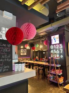 een restaurant met roze lantaarns die aan het plafond hangen bij Moxy Bucharest Old Town in Boekarest