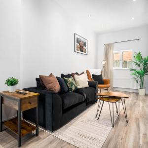 a living room with a black couch and a table at Cozy Apartment - On street parking - Rowley Regis 49AG in Halesowen +12 photos