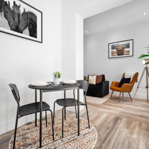 a dining room with a table and chairs in a living room at Cozy Apartment - On street parking - Rowley Regis 49AG in Halesowen