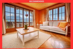 Una sala de estar con un sofá blanco y una mesa. en Chalet 6 personnes avec sauna, en Leysin