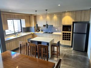 a kitchen with a table and a refrigerator at Sweet Home in Cochabamba
