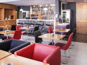 um restaurante com mesas, cadeiras e um bar em ibis Jaboticabal em Jabuticabal