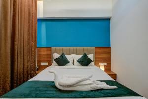 a bedroom with a bed with a towel on it at Silverkey Hotel Yelahanka in Bangalore +40 photos