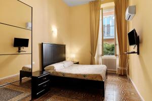 ein Schlafzimmer mit einem Bett, einem Spiegel und einem Fenster in der Unterkunft Botafogo in Bacezza