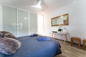 a bedroom with a blue bed and a mirror at Beach Side Apartments Calahonda in Sitio de Calahonda