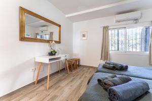 a bedroom with two beds and a desk and a mirror at Beach Side Apartments Calahonda in Sitio de Calahonda