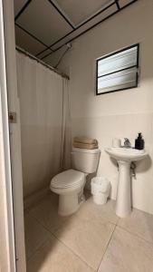 a bathroom with a toilet and a sink at Cozy Jayuya Apartment with City, Garden, and Mountain Views in Jayuya