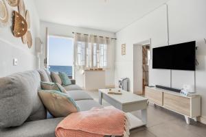 ein Wohnzimmer mit Couch und Flachbildfernseher in der Unterkunft La Casita De La Playa in Puerto de las Lajas