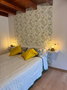 a bedroom with a bed with two yellow pillows at Casa Criseva II in Avín