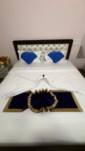 a white bed with blue pillows and a dress on it at White Rabbit Rooms in Bangalore