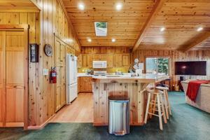 Chambers LodgeTahoe Getaway的小木屋里的厨房，墙壁是木头的，还有一个厨房岛台。