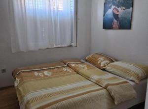 two beds in a room with a window at Holiday Home Green Oasis Lika in Lovinac +4 photos