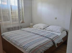 a bed in a white room with a window at Holiday Home Green Oasis Lika in Lovinac